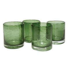 four green glass tumblers sitting next to each other