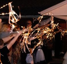 a group of people standing around each other holding sparklers