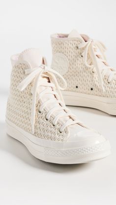 a pair of white sneakers with laces on them