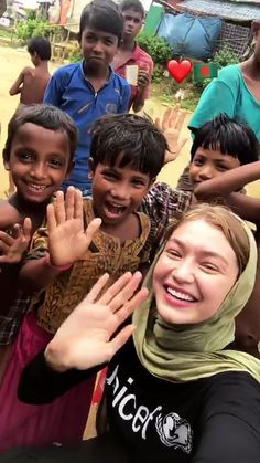 a group of young children standing next to each other with their hands in the air