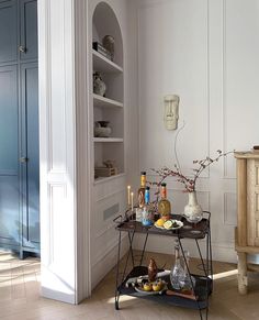 a table with drinks on it in the middle of a room next to an open door