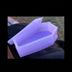 a purple container sitting on top of a black bag