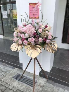 a large arrangement of pink flowers on a stand