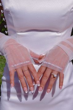 a woman in white dress holding her hands with two fingers on the other side of her body