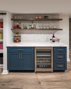 a wine cooler in the middle of a kitchen with open shelving and shelves above it