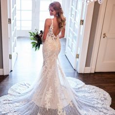 a woman in a wedding dress is standing on the floor with her back to the camera