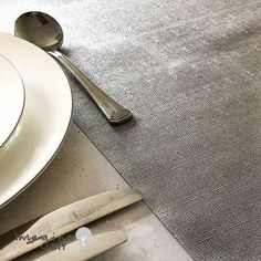 a table setting with utensils and silverware on the placemat, next to a knife and fork