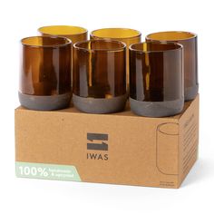 four brown glass cups sitting on top of a cardboard box