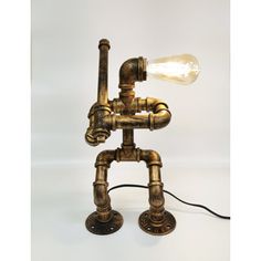 an old fashioned lamp made out of pipes with a light bulb on the end and a cord attached to it