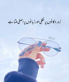 someone holding up their glasses in front of the sky with an arabic quote on it