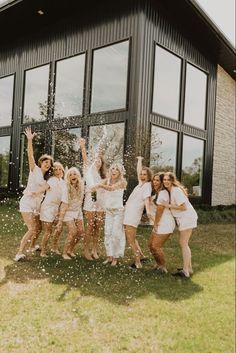 a group of young women standing next to each other in front of a building