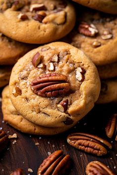 chocolate chip cookies with pecans and pecans in the middle on a wooden surface