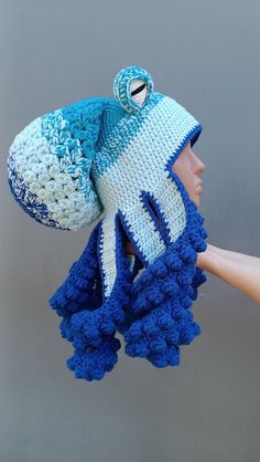 a crocheted hat and scarf hanging from a mannequin's head