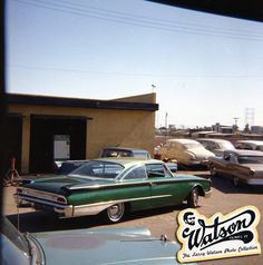 several old cars are parked in a parking lot