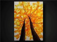 two trees with yellow leaves on them in front of a black background and an orange sky