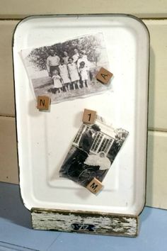 an old photo with scrabbles is displayed on a white tray next to a wall