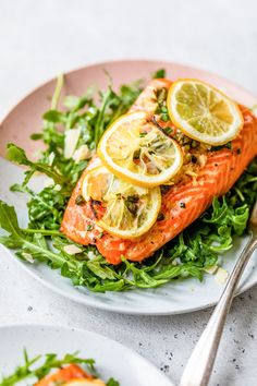 salmon with lemons and greens on a plate