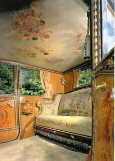 the interior of an old fashioned car painted with gold and white flowers on it's walls