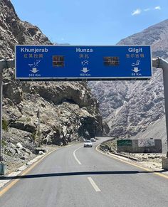 a blue highway sign on the side of a mountain road