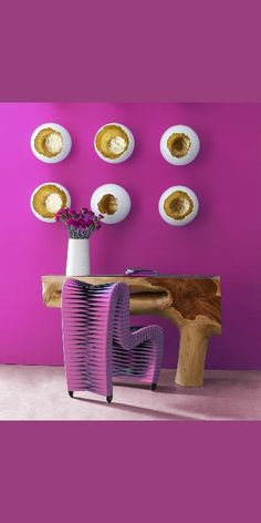 a vase with flowers in it sitting next to a table and some plates on the wall