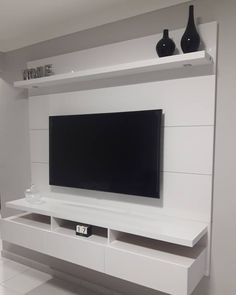 a flat screen tv mounted to the side of a white entertainment center in a living room