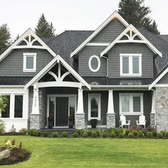 a large gray house with white trim and windows