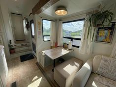 the inside of a camper with two chairs and a table in front of it