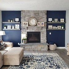 a living room with blue walls and a stone fireplace