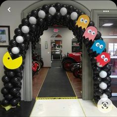 an entrance decorated with black, white and yellow balloons that look like pacmanes