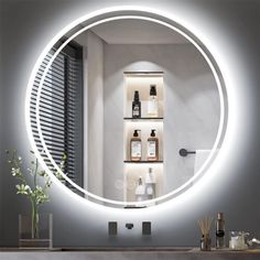 a bathroom with a round mirror on the wall above it and bottles in front of it