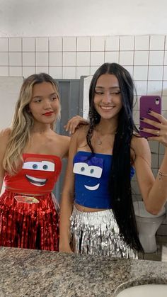 two young women standing next to each other in a bathroom