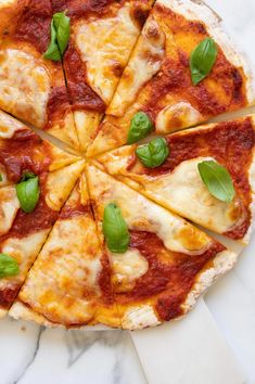 a pizza cut into eight slices with basil on top