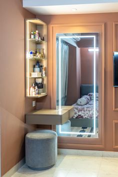 a room with a bed, desk and mirror in it's corner next to a closet