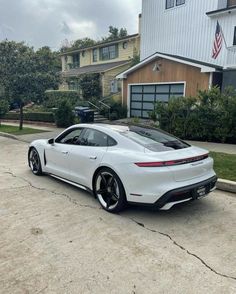 a white sports car parked in front of a house