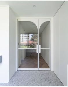 an empty room with white walls and glass doors