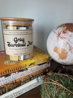 some books are stacked on top of each other and one is next to a globe