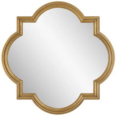 a gold framed mirror with an ornate design on the front and back side, against a white background