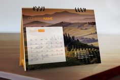 a desk calendar sitting on top of a wooden table