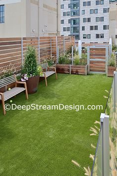 an apartment balcony with green grass and potted plants on the roof top deck area