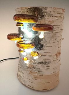 a light that is on top of a tree trunk in the shape of a vase