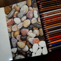 colored pencils are next to a drawing of rocks