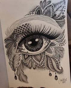 a drawing of an eye with feathers on it