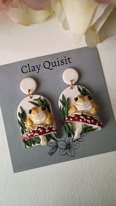 a pair of earrings with a frog on it