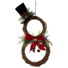 a christmas wreath with a top hat and red bow hanging from it's side