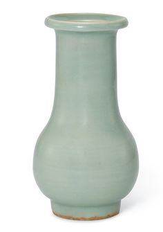 a light green vase sitting on top of a white table