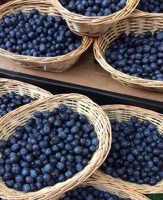 baskets filled with blueberries sitting on top of a table