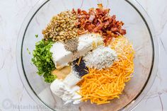 a glass bowl filled with cheese, bacon and other ingredients to make an appetizer