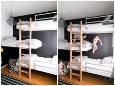 two children climbing up and down bunk beds in a room with black walls, white bedding and wooden ladders