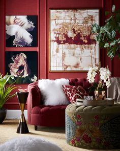 a living room with red walls and pictures on the wall