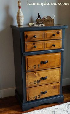 an old dresser is painted black and has numbers on it